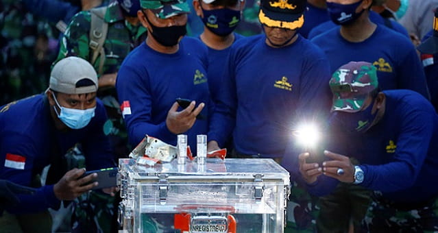 Integrantes da Marinha da Indonésia tiram fotos do gravador de dados recuperado de avião da Sriwijaya Air