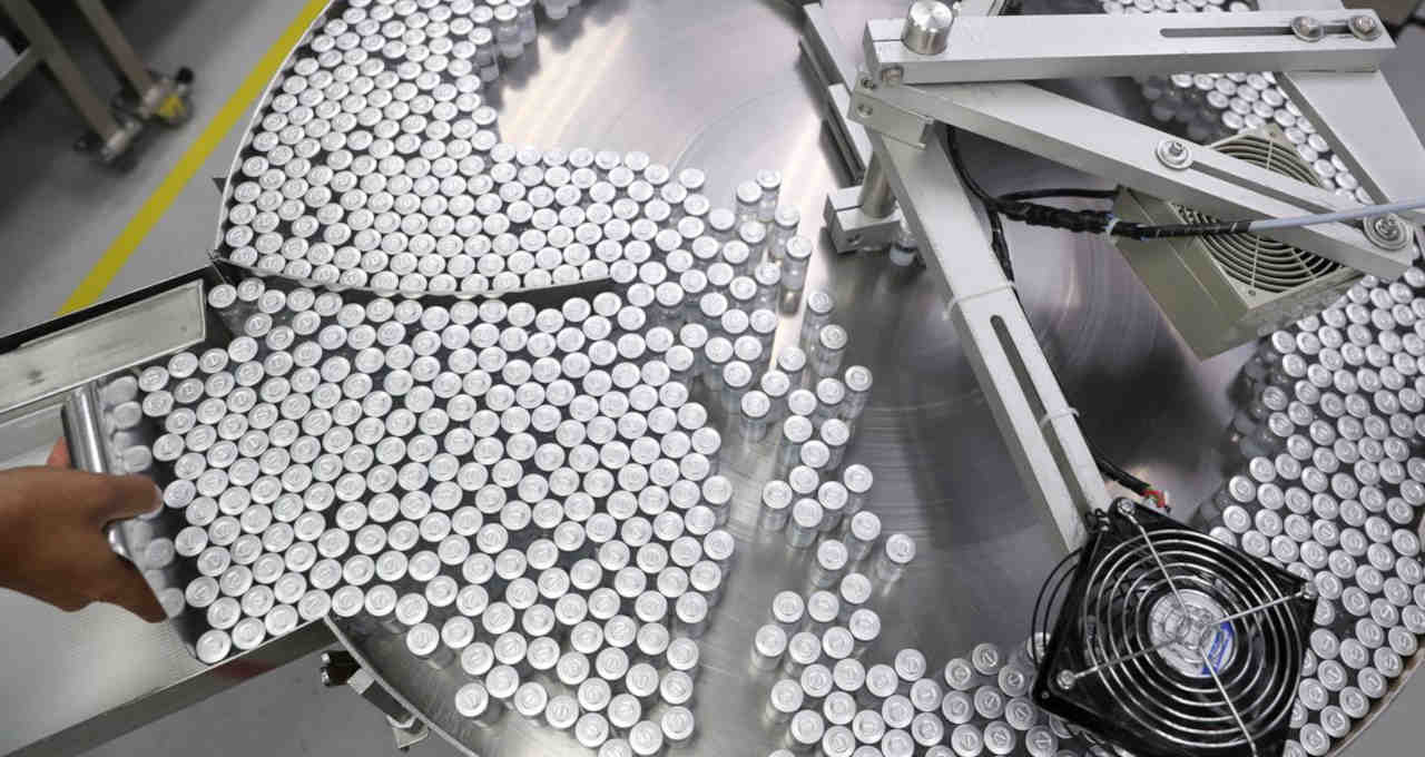 An employee puts on an equipment vials containing CoronaVac, Sinovac's vaccine against the coronavirus disease (COVID-19), at Butantan biomedical production center in Sao Paulo, Brazil January 22, 2021
