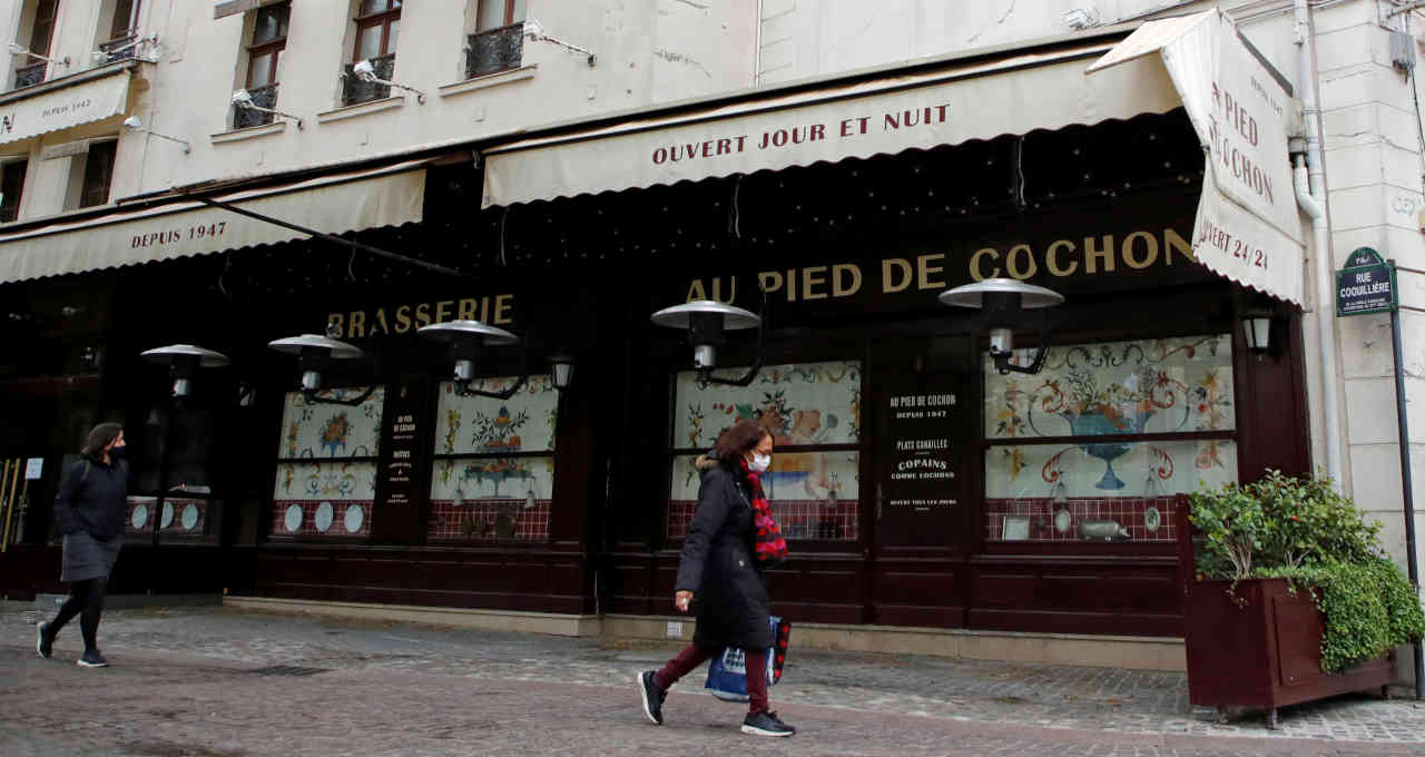 Pessoas usando máscaras passam por restaurante fechado em Paris em meio à pandemia de Covid-19 na França 06/05/2021