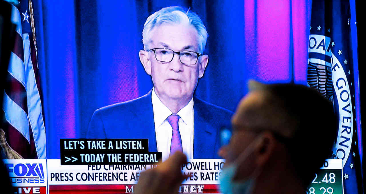 Operador trabalha diante de tela com transmissão de fala do presidente do Fed, Jerome Powell
