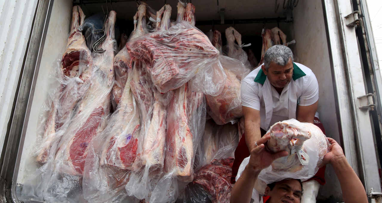 Trabalhadores descarregam caminhão com carne bovina em São Paulo