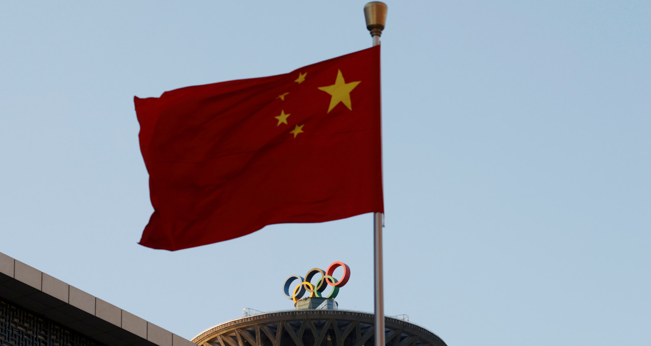 Bandeira da China sobre os anéis olímpicos na Torre Olímpica em Pequim