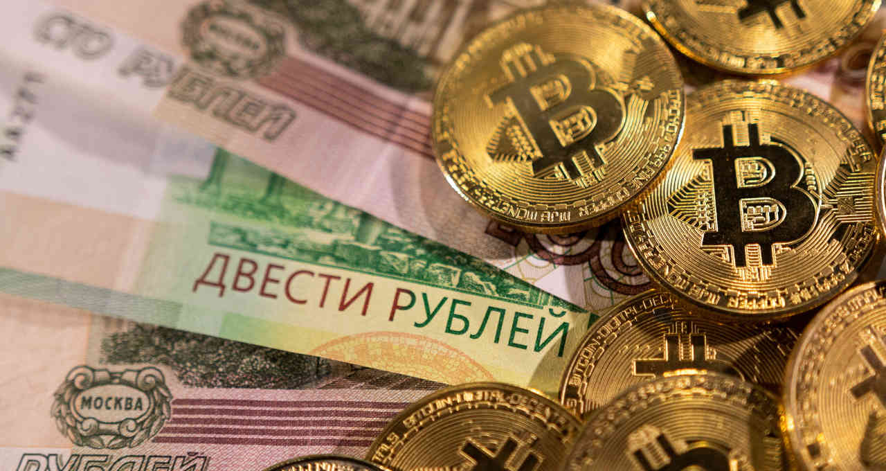 Notas de rublo russo ao lado de representações de bitcoin