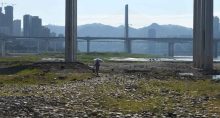 Mulher caminha no leito do rio Yangtze exposto em Chongqing