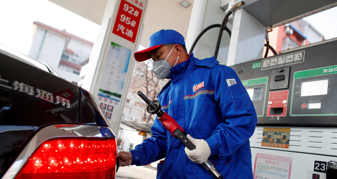 Atendente reabastece carro em um posto de gasolina Sinopec, em Pequim