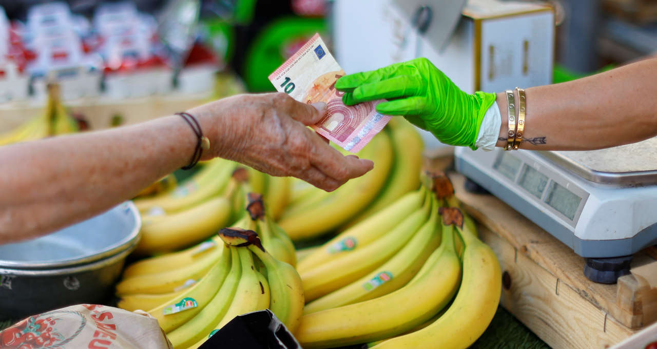 Comprador paga mercadorias com nota de 10 euros em mercado em Nice, França